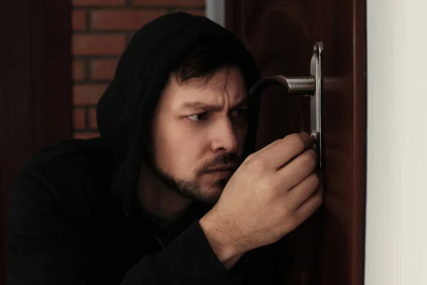 Man plockar dörrlåset för att bryta sig in i huset. Brott — Stockfoto