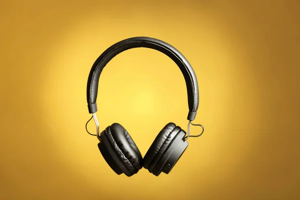Fones de ouvido elegantes com almofadas no fundo de cor — Fotografia de Stock