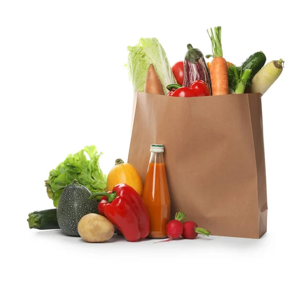 Bolsa de papel con verduras frescas y botella de jugo sobre fondo blanco — Foto de Stock