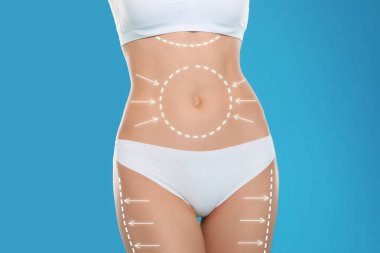 Young slim woman with arrows on body against color background, closeup. Beauty and health concept