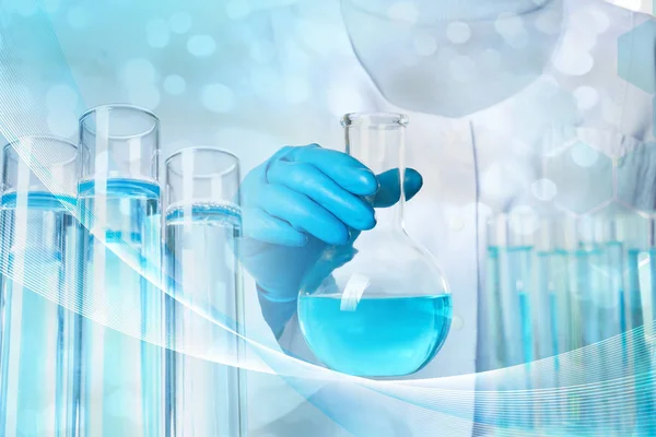 Bilim adamı elinde cam şişesi sıvı, yakın çekim. Çözelti kimyası