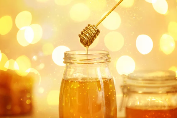 Μέλι στάζει από την Άρκτος σε βάζο με θολά φώτα — Φωτογραφία Αρχείου