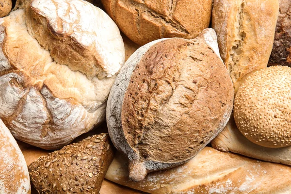Diferentes tipos de pan fresco como fondo, vista superior — Foto de Stock