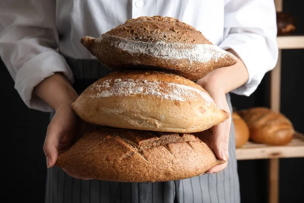Panadero sosteniendo panes en el interior, primer plano — Foto de Stock