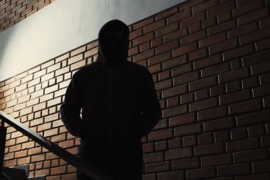 Kapüşonlu kapalı gizemli adamın silueti. Tehlikeli suçlu