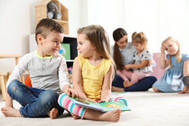 Sevimli küçük çocuklar birlikte kapalı kitap okuma, metin için alan. Öğrenme ve oynama