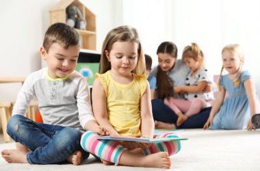 Sevimli küçük çocuklar birlikte kapalı kitap okuma, metin için alan. Öğrenme ve oynama
