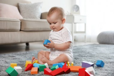 Sevimli kız bebek odada yapı taşları ile oynarken