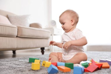 Sevimli kız bebek odada yapı taşları ile oynarken