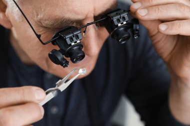 Atölyede değerli değerli taş değerlendiren erkek kuyumcu, closeup