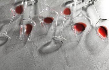 Gri arka plan üzerinde kırmızı şarap ile farklı bardak, düz yatıyordu. Metin için alan