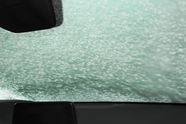 Automobile windshield covered with foam, view from inside. Car wash service — Stock Photo, Image