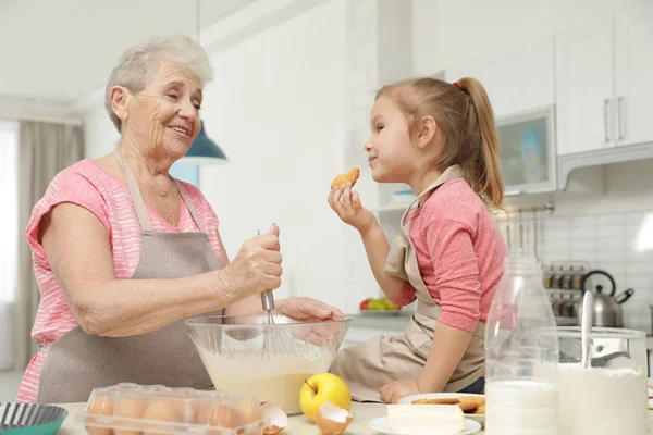 可爱的女孩和她的祖母在厨房做饭 — 图库照片