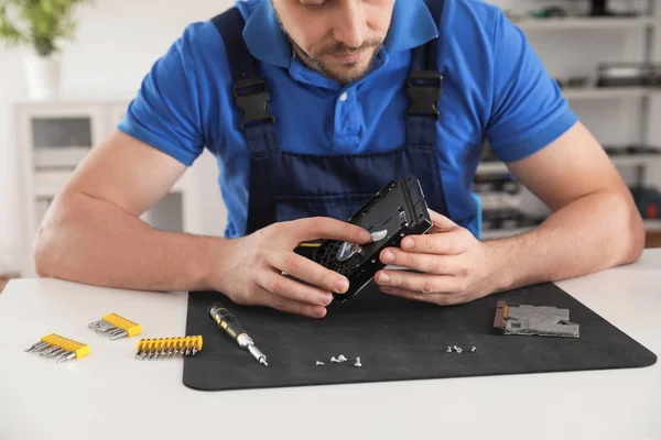 Técnico masculino que repara el disco duro en la mesa en el interior, primer plano —  Fotos de Stock