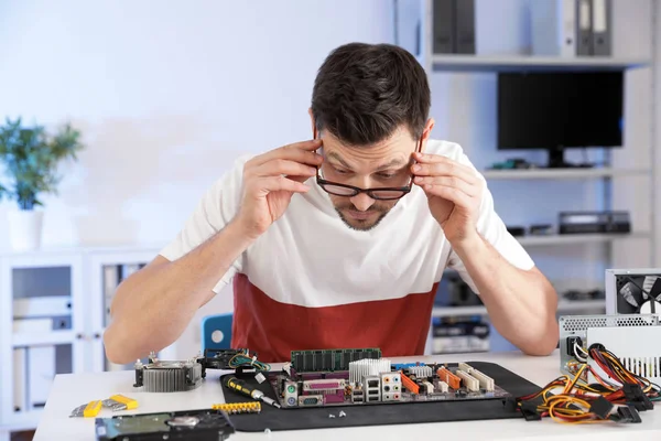 Técnico masculino reparando la placa base en la mesa en el interior —  Fotos de Stock