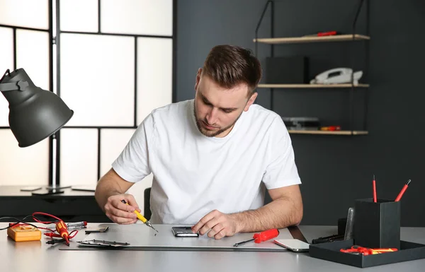 Technicien réparer téléphone portable à table dans l'atelier — Photo