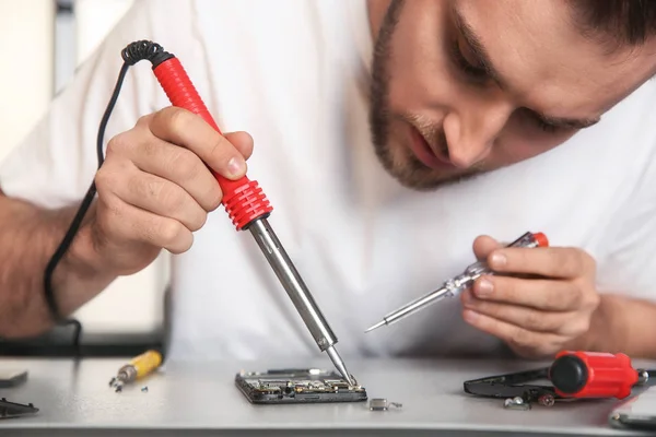 Tecnico riparazione telefono cellulare a tavola, primo piano — Foto Stock