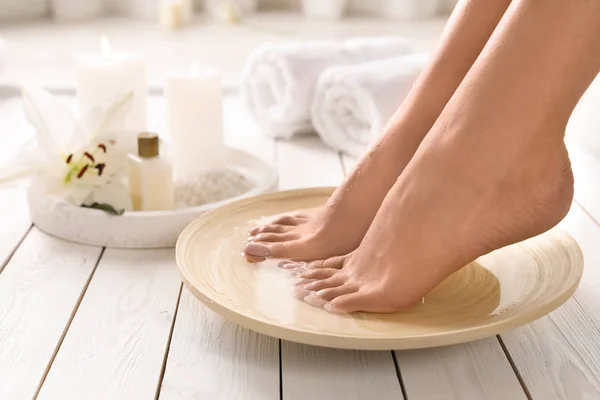 Closeup pohled na ženu namočené nohama do misky s vodou na dřevěné podlaze, místo pro text. Lázeňská léčba — Stock fotografie