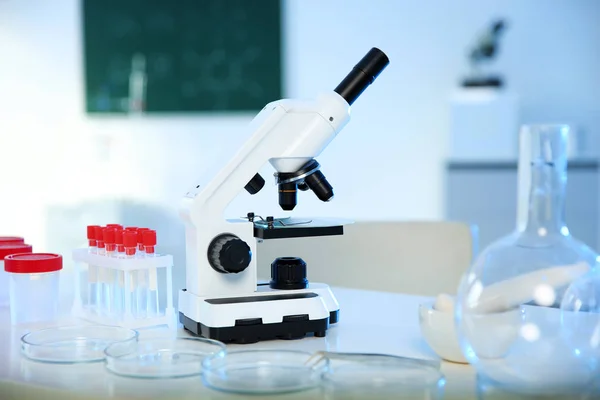 Professionellt Mikroskop och glasföremål på bordet i kemi laboratoriet — Stockfoto