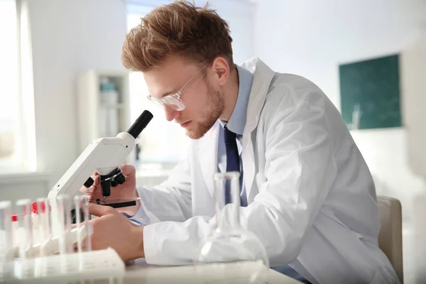 Mužský vědec používající moderní mikroskop v chemické laboratoři — Stock fotografie