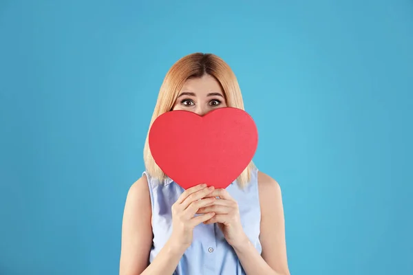 Gyönyörű nő szív alakú doboz színes háttér — Stock Fotó