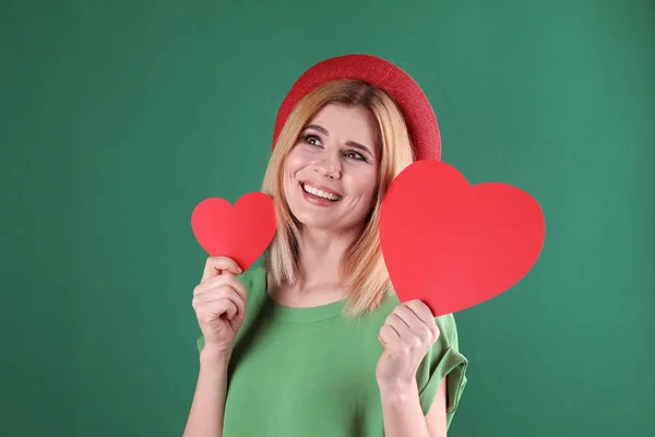 Hermosa mujer con corazones de papel sobre fondo de color — Foto de Stock