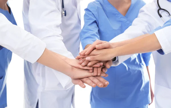 Equipa de médicos a juntar as mãos no fundo branco, de perto. Conceito de unidade — Fotografia de Stock