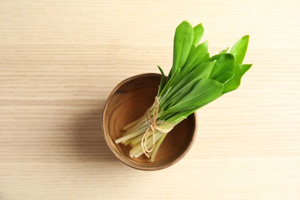 Tigela com molho de alho selvagem ou ramson na mesa de madeira, vista superior — Fotografia de Stock