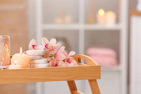 Skladba se svíčkami, květinami a kameny na dřevěném stole v lázeňském salonu. Místo pro text — Stock fotografie