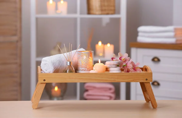 Composição com velas, flores e pedras na mesa de madeira no salão de spa — Fotografia de Stock