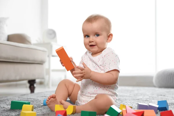 Niedliches Baby-Mädchen spielt mit Bausteinen im Zimmer — Stockfoto