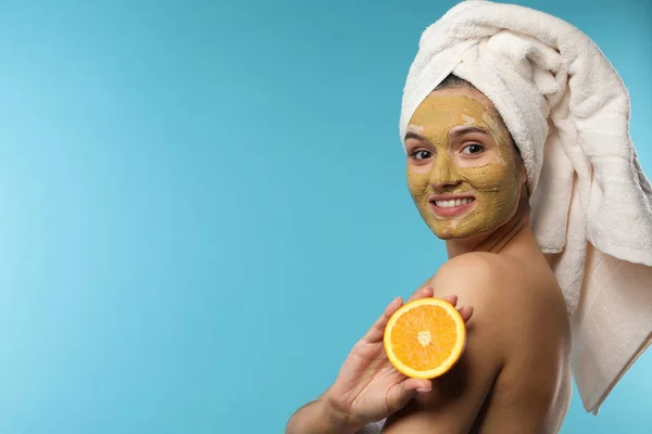 Mooie vrouw met masker op gezicht en gesneden Oranje tegen kleur achtergrond. Ruimte voor tekst — Stockfoto