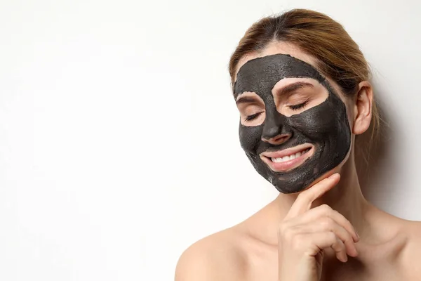 Piękna kobieta z czarną maską na twarzy przed jasnym tłem. Miejsce na tekst — Zdjęcie stockowe