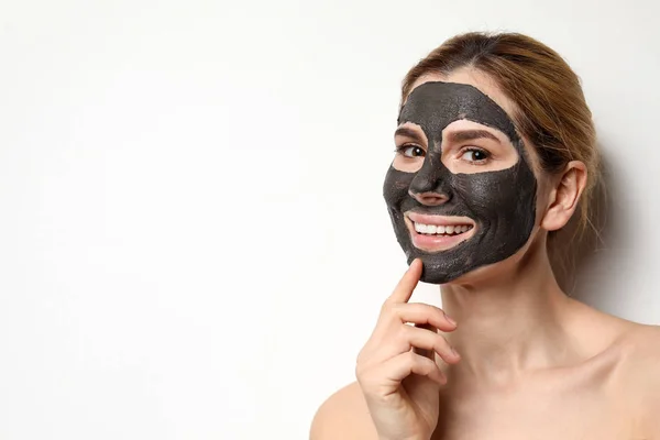 Piękna kobieta z czarną maską na twarzy przed jasnym tłem. Miejsce na tekst — Zdjęcie stockowe