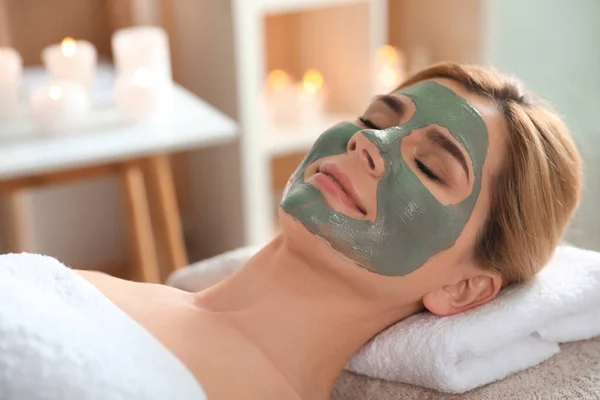 Belle femme avec masque sur le visage relaxant dans le salon de spa — Photo