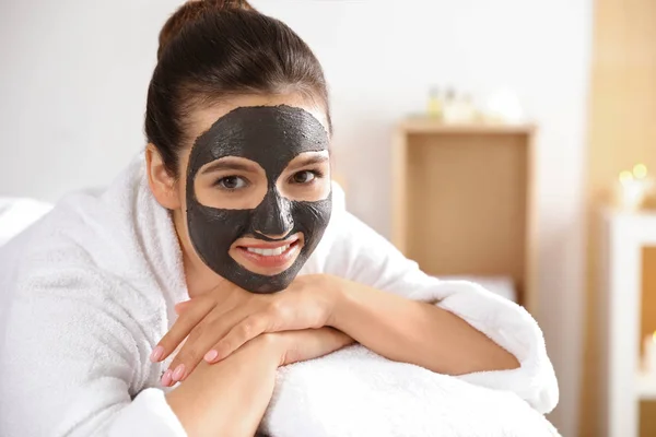 Krásná žena s černou maskou na obličeji relaxační v lázeňském salonu. Místo pro text — Stock fotografie