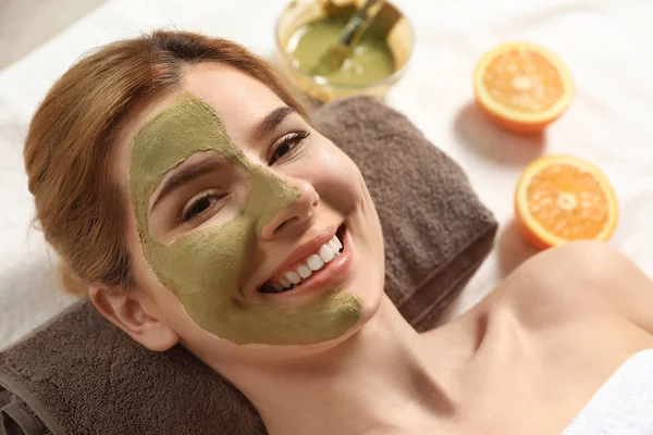 Wanita cantik dengan topeng di wajah santai di spa salon, closeup — Stok Foto