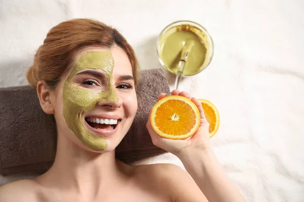 Wanita dengan topeng di wajah dan memotong orange relaxing di spa salon, top view. Ruang untuk teks — Stok Foto