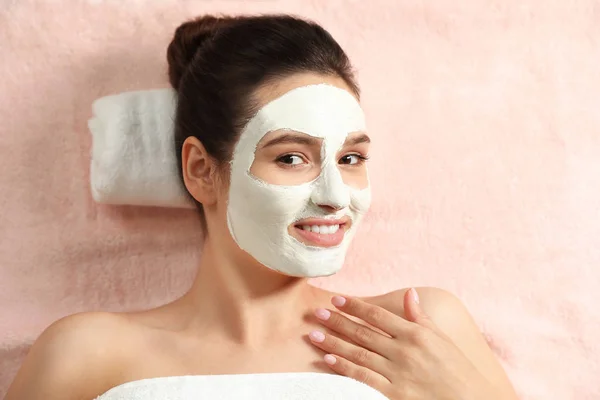 Wanita cantik dengan topeng putih di wajah santai di spa salon, pandangan atas — Stok Foto