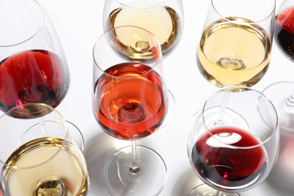 Different glasses with wine on white background