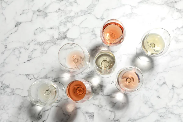 Diferentes copos com vinho no fundo de mármore, flat lay — Fotografia de Stock