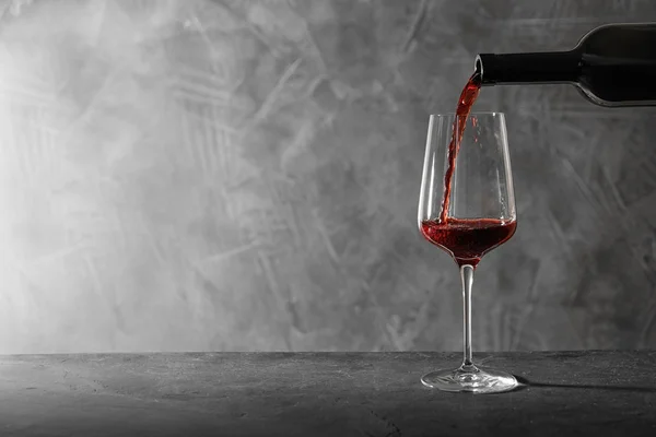 Öntött vörös bort palackból üvegbe az asztalra. Szóköz a szöveghez — Stock Fotó