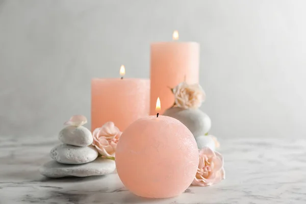 Палаючі свічки, спа-камені та квіти на столі. Простір для тексту — стокове фото