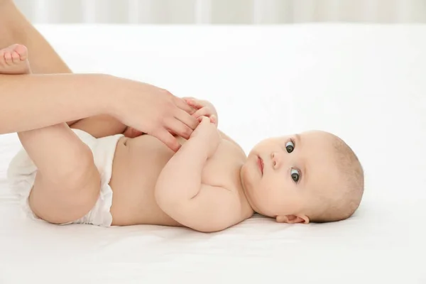 Mutter mit ihrem süßen Kind im Bett. Babymassage und Übungen — Stockfoto