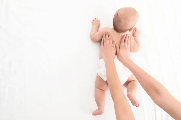 Draufsicht auf Mutter und ihr süßes Kind auf weißem Bett, Platz für Text. Babymassage und Übungen — Stockfoto