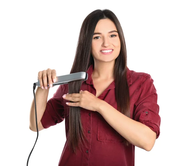 Mujer joven usando plancha para el cabello sobre fondo blanco —  Fotos de Stock