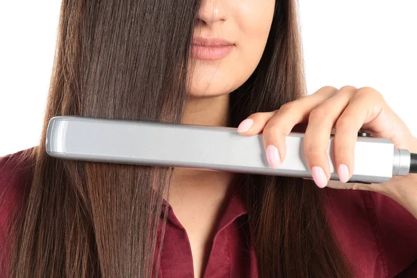 Młoda kobieta za pomocą żelaza do włosów na białym tle, zbliżenie — Zdjęcie stockowe