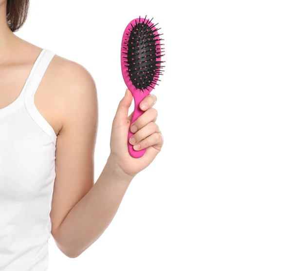 Mulher segurando escova de cabelo no fundo branco, close-up — Fotografia de Stock