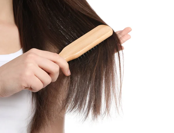 Mujer con cepillo de pelo sobre fondo blanco, primer plano — Foto de Stock