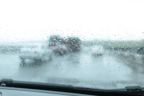 透过湿车窗的郊区道路模糊视图。雨天 — 图库照片